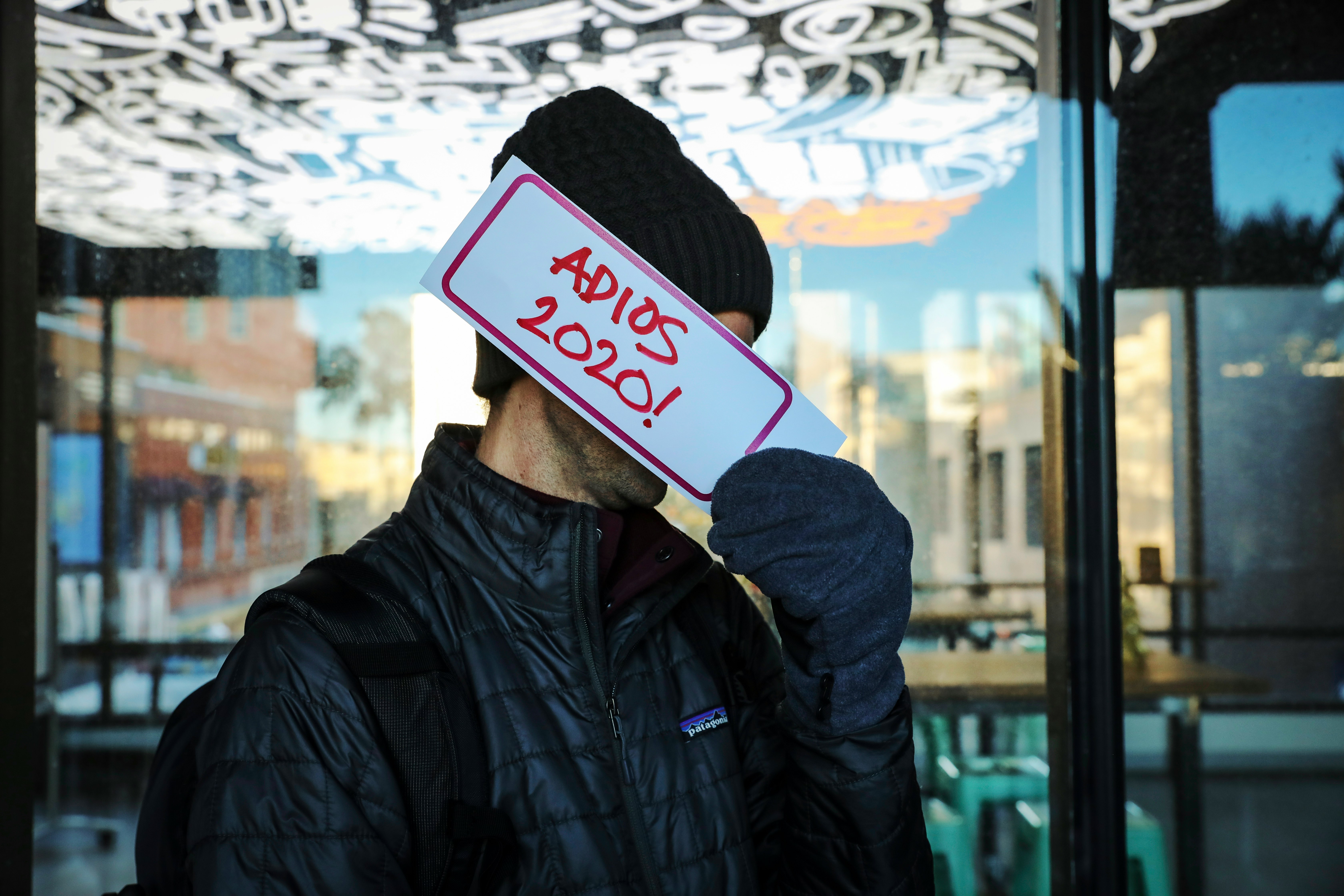 person in black jacket holding white and red card